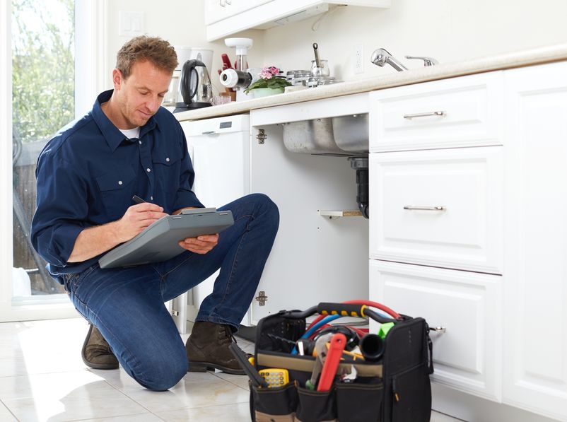 plumber fixing leaking kitchen