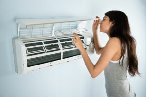 woman making sure air conditioner is ready for summer